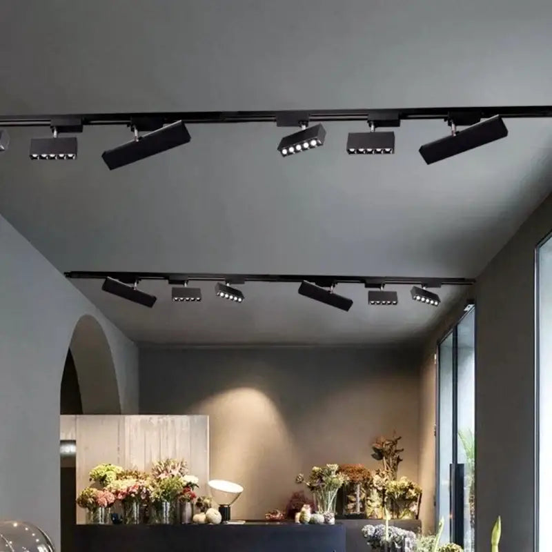Modern black led linear grille track spotlights with adjustable heads mounted on a living room ceiling