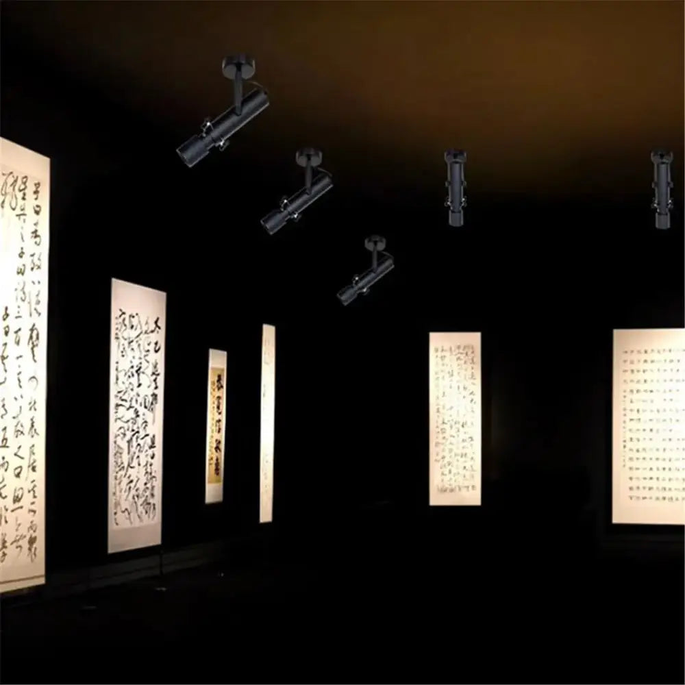 Modern black and white led track light featuring black cylindrical spotlights with adjustable heads mounted on ceiling