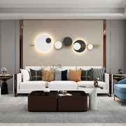Modern black and white led wall lamps featuring geometric illuminated discs on a gold-toned bar for bedroom lighting