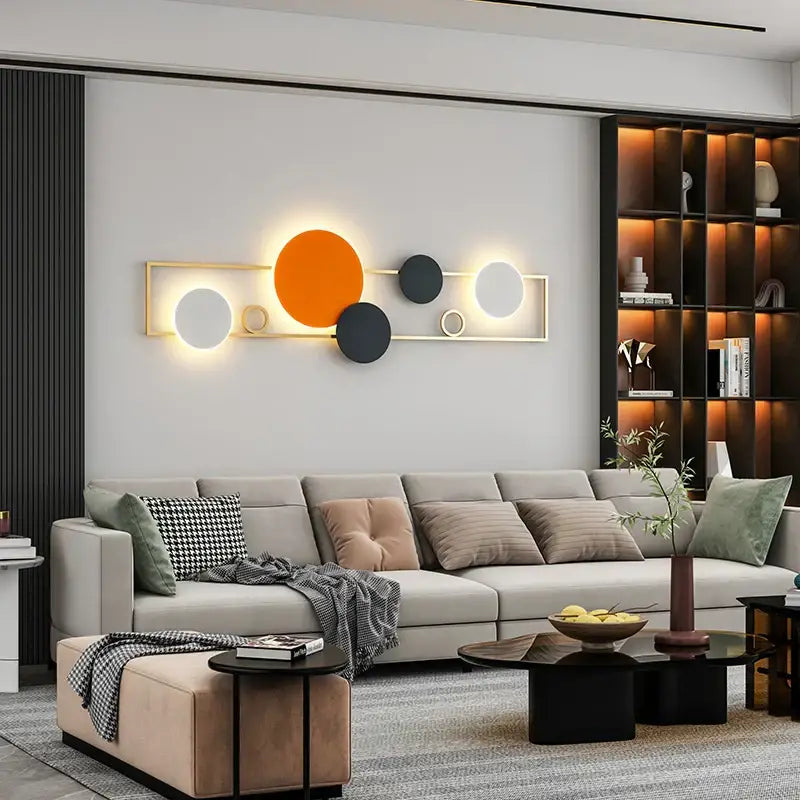 Modern black and white led wall lamps featuring geometric illuminated discs in orange black and white within gold frame