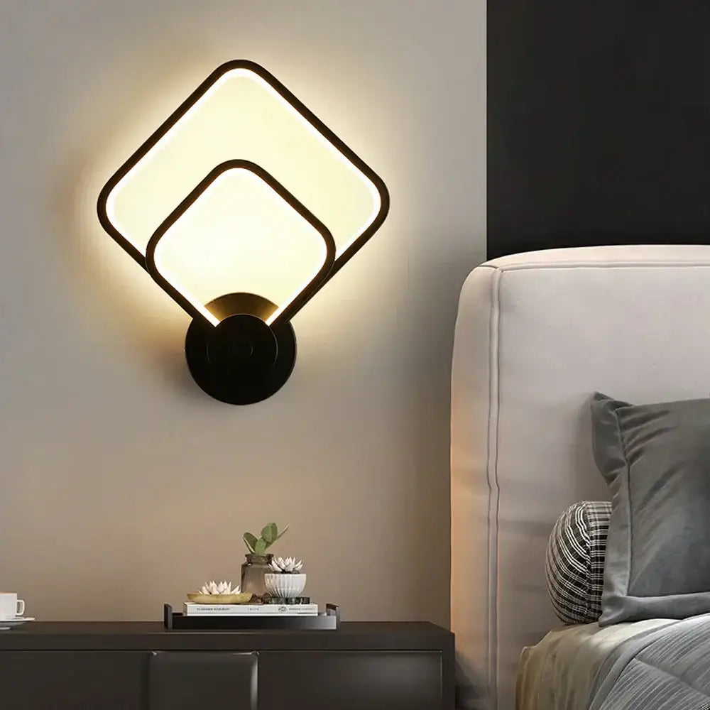 Modern black and white led wall light with two overlapping square led panels emitting warm soft glow for bedroom use