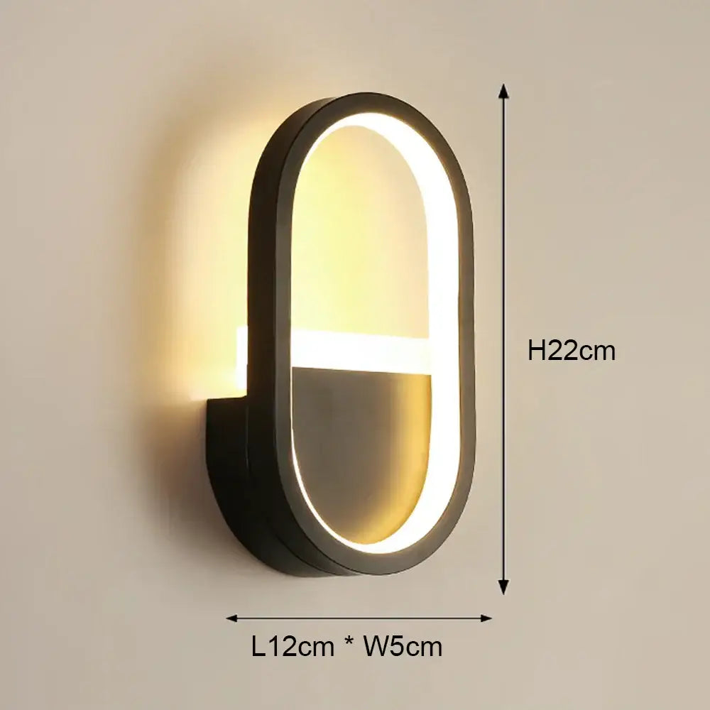 Modern black and white led wall light featuring a black oval led wall sconce with a glowing light strip for bedroom use