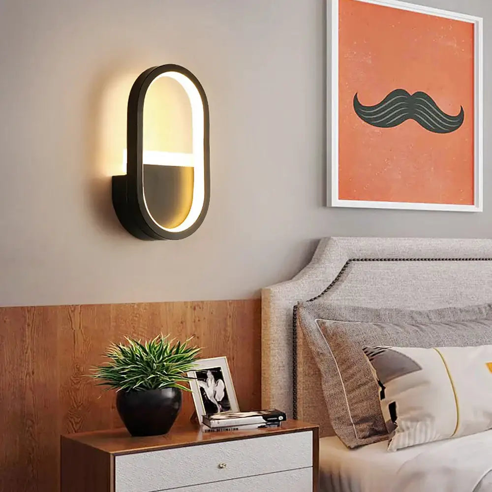 Modern black oval led wall light with warm glowing light for bedroom geometric sconce decor and illumination
