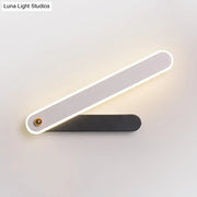 Modern black and white led wall mount fixture with sleek design and illuminated edge casting warm light for bedroom use