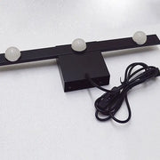 Modern black and white linear wall lighting with three frosted globe bulbs and a coiled power cord for warm white light