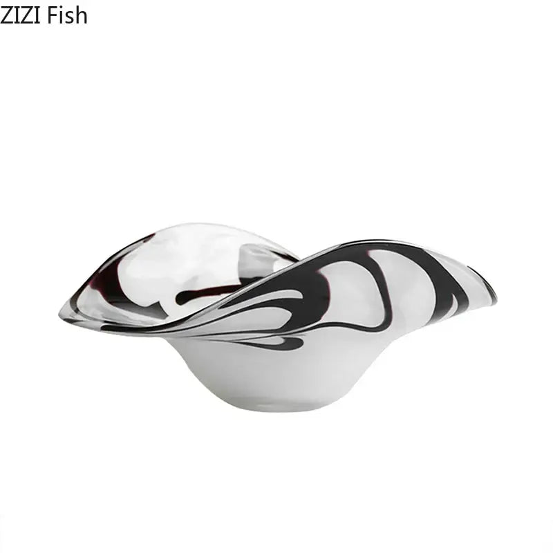 A modern glass fruit plate with bold black swirls on a translucent white base for elegant dining room use
