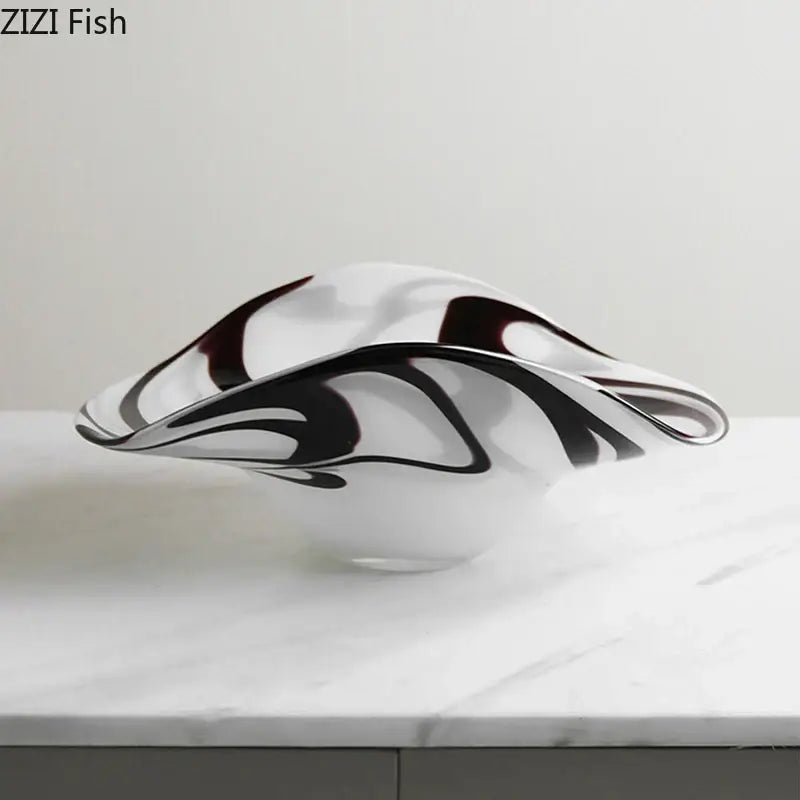 A modern glass fruit plate with sleek black and deep burgundy swirls on a translucent white base
