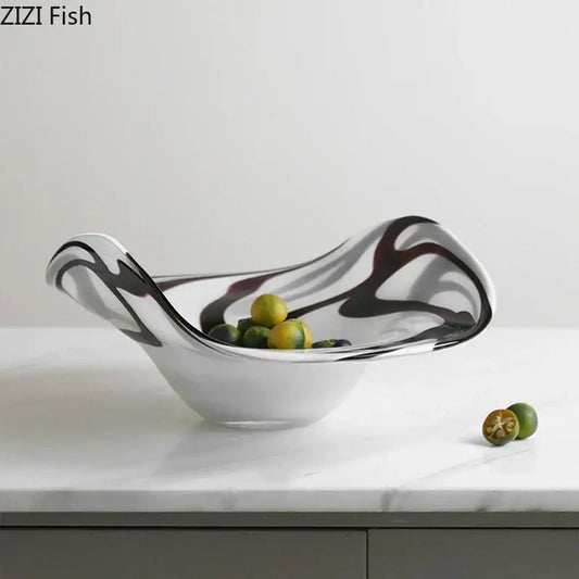 A sleek modern glass fruit plate with black and white marbled patterns in a smooth curved bowl design