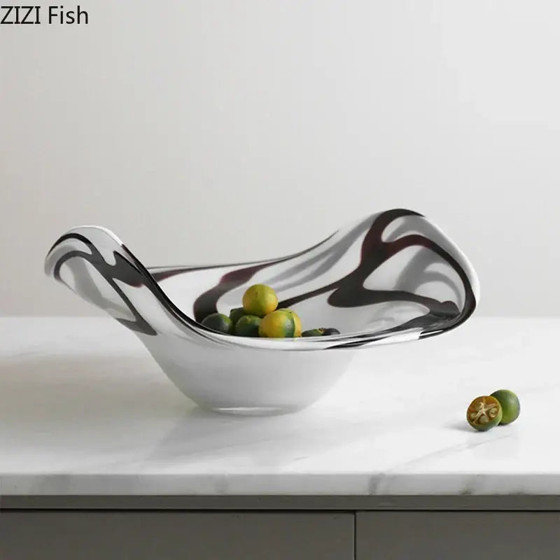 A sleek modern glass fruit plate with black and white marbled patterns in a smooth curved bowl design