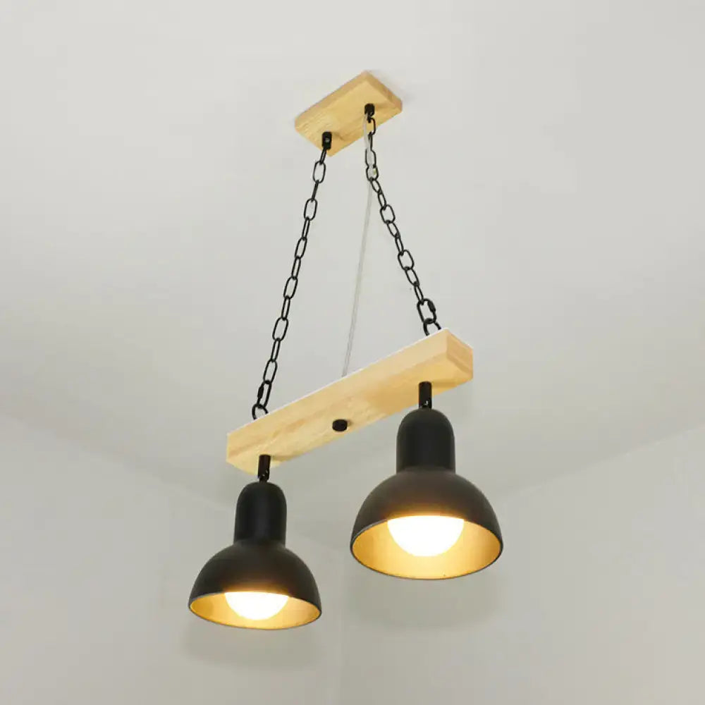 Industrial-style pendant light with two black white metal shades suspended by chains from a natural wood beam