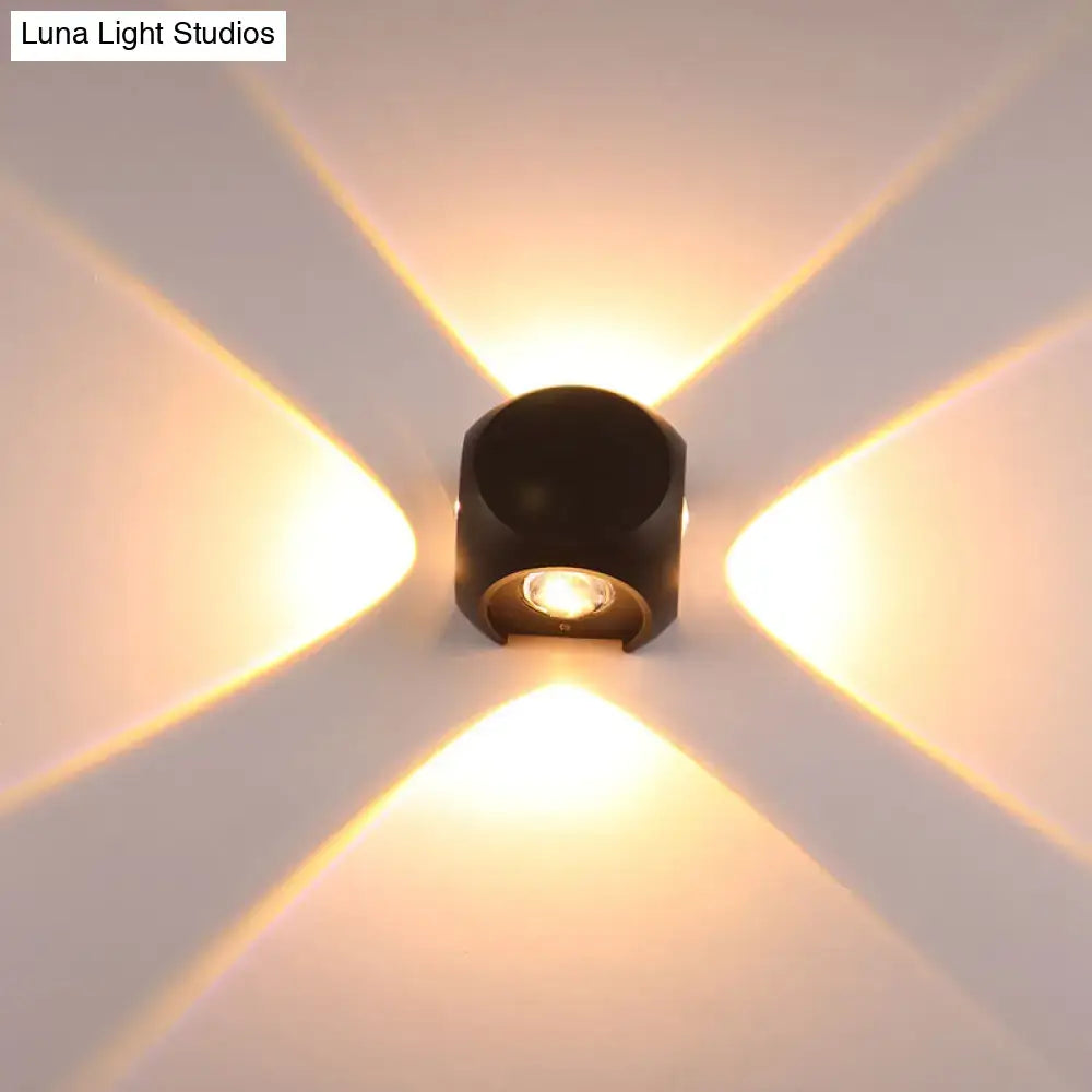 Modern black cylindrical mini cube wall lamp with warm golden beams mounted in living room sconce