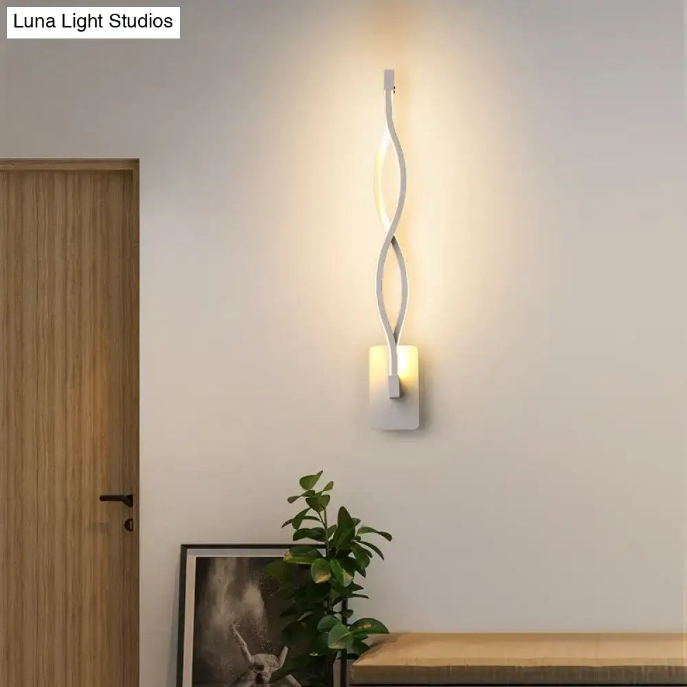 Modern black and white wall lamp with a musical note design and sleek twisted acrylic shade emitting warm ambient light