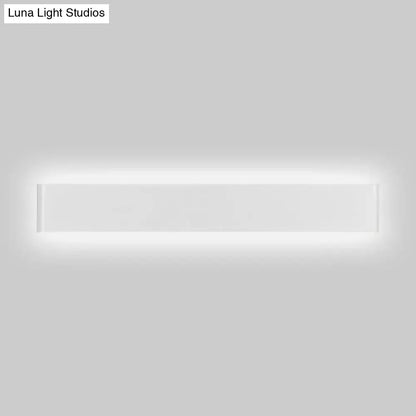 Modern black and white wall lamp with rectangular metal shade and sleek white finish illuminating living room space