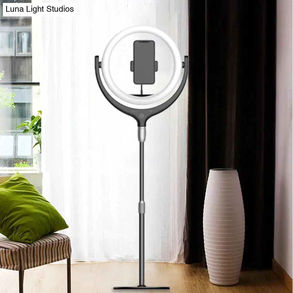 A sleek modern black and silver led mirror lamp ring light on adjustable stand for smartphone streaming and photography