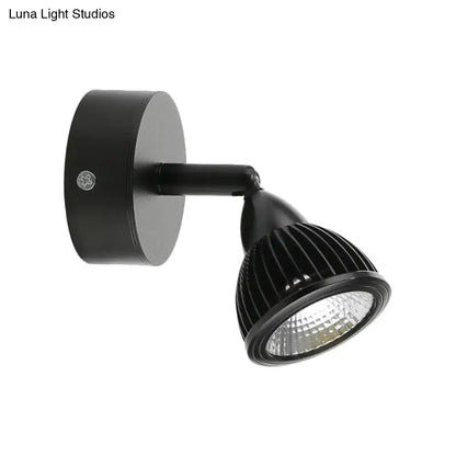 Modern black and white wall light with matte black ribbed adjustable spotlight and sleek cylindrical base for bedroom use
