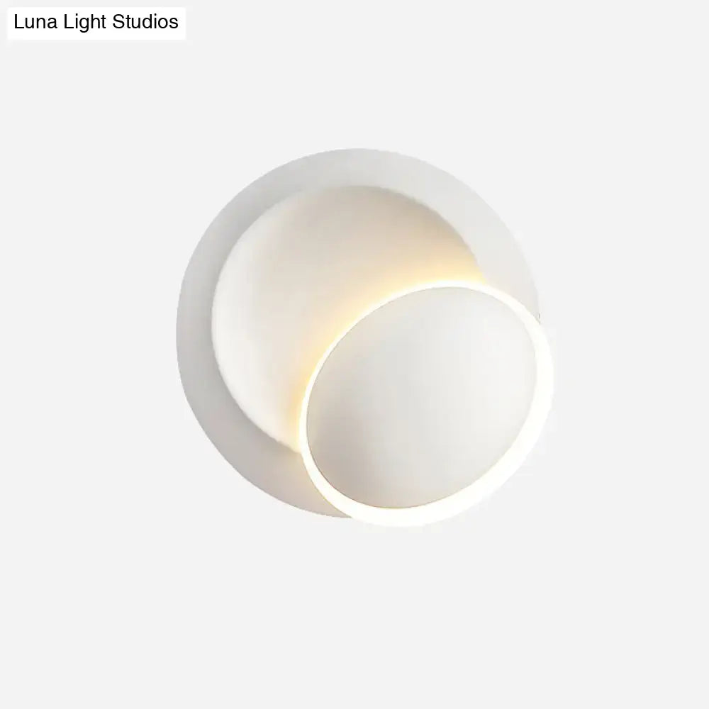 Modern black and white rotating eclipse wall lamp with white rotating circular sconce and soft ambient lighting