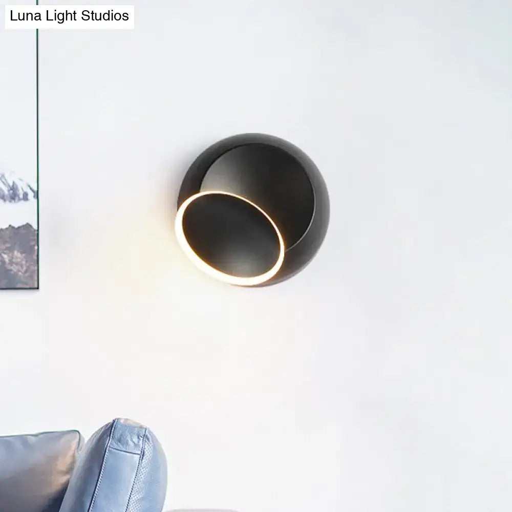 Modern black wall lamp with white rotating led circular light ring designed as eclipse for bedroom use