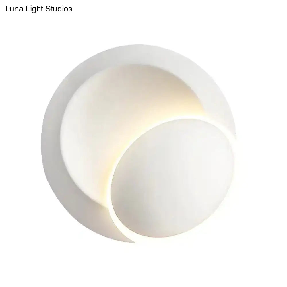Modern black and white wall lamp with sleek overlapping circular design and soft ambient white rotating light for bedroom