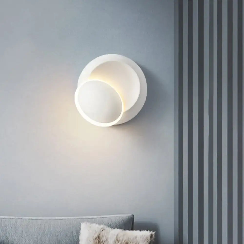 Modern black and white rotating eclipse wall lamp with a sleek white rotating circular minimalist wall sconce design