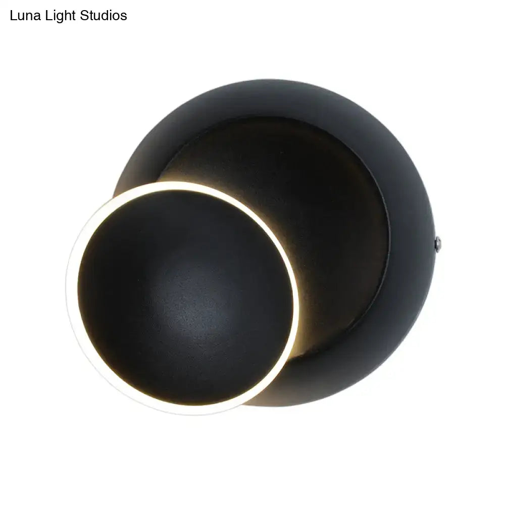 Modern black matte wall lamp with white rotating eclipse design and illuminated ring accent for bedroom use