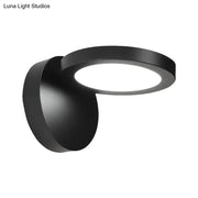 Modern black circular wall light fixture with sleek rotating design for bedroom glow and contemporary ambiance