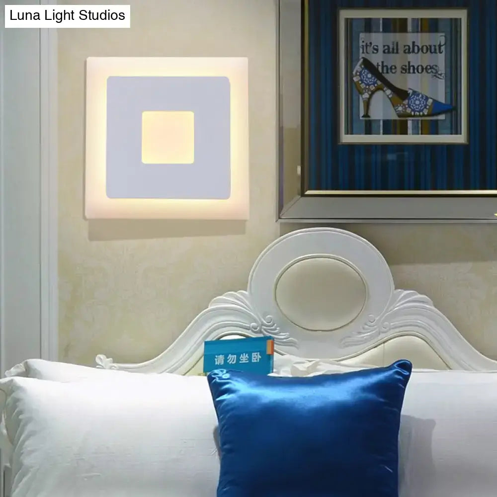 Modern black and white square wall sconce lamp with layered geometric design and soft glowing center in muted gray tones