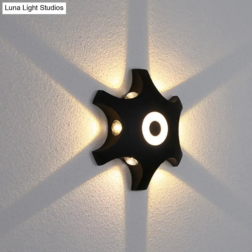 Modern black star led wall light with four illuminated arms and warm white light for bedroom decor