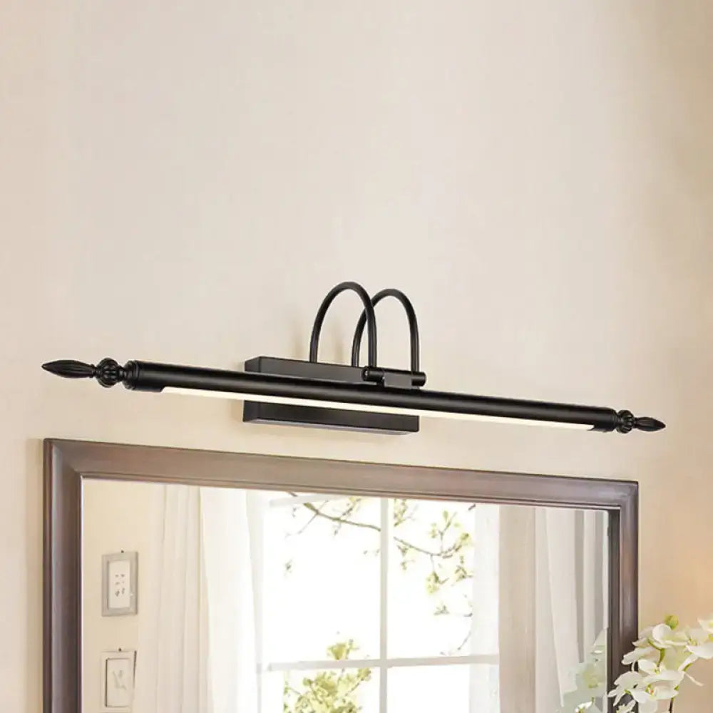 Black wrought iron vanity lighting with ornate finials and curved arches providing white warm light for bathroom use