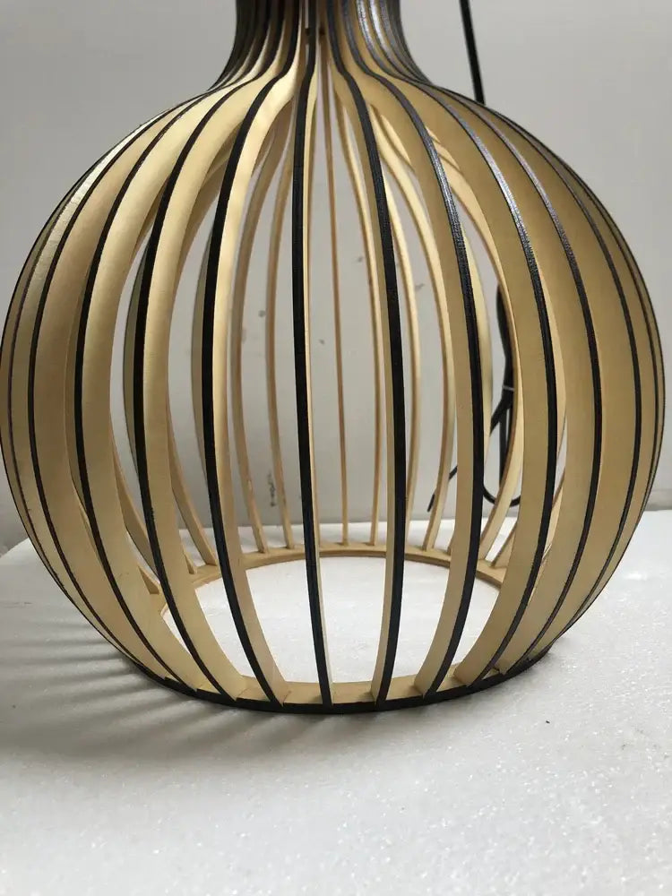 A modern spherical pendant light with a white wood cage frame and black accents for living room use