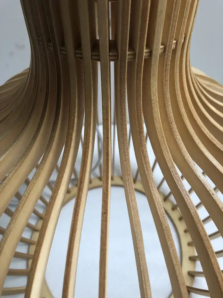 Modern light-brown wooden pendant light with curved slats paired with a modern black and white wood cage design