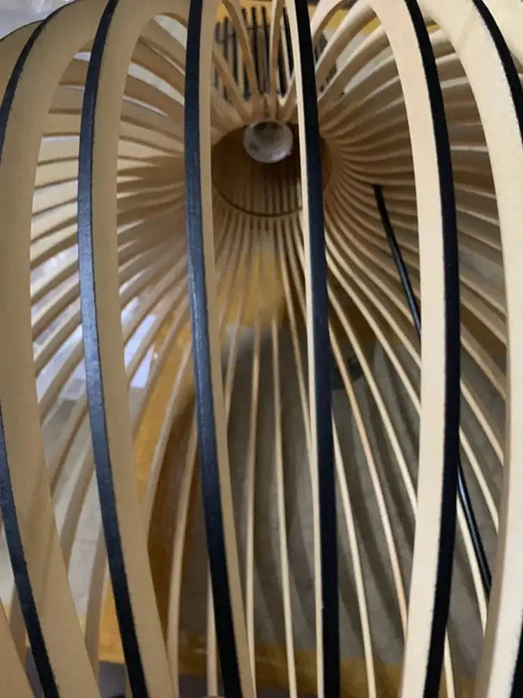 A modern pendant light with radial light-colored white wood cage and black accents for living room use