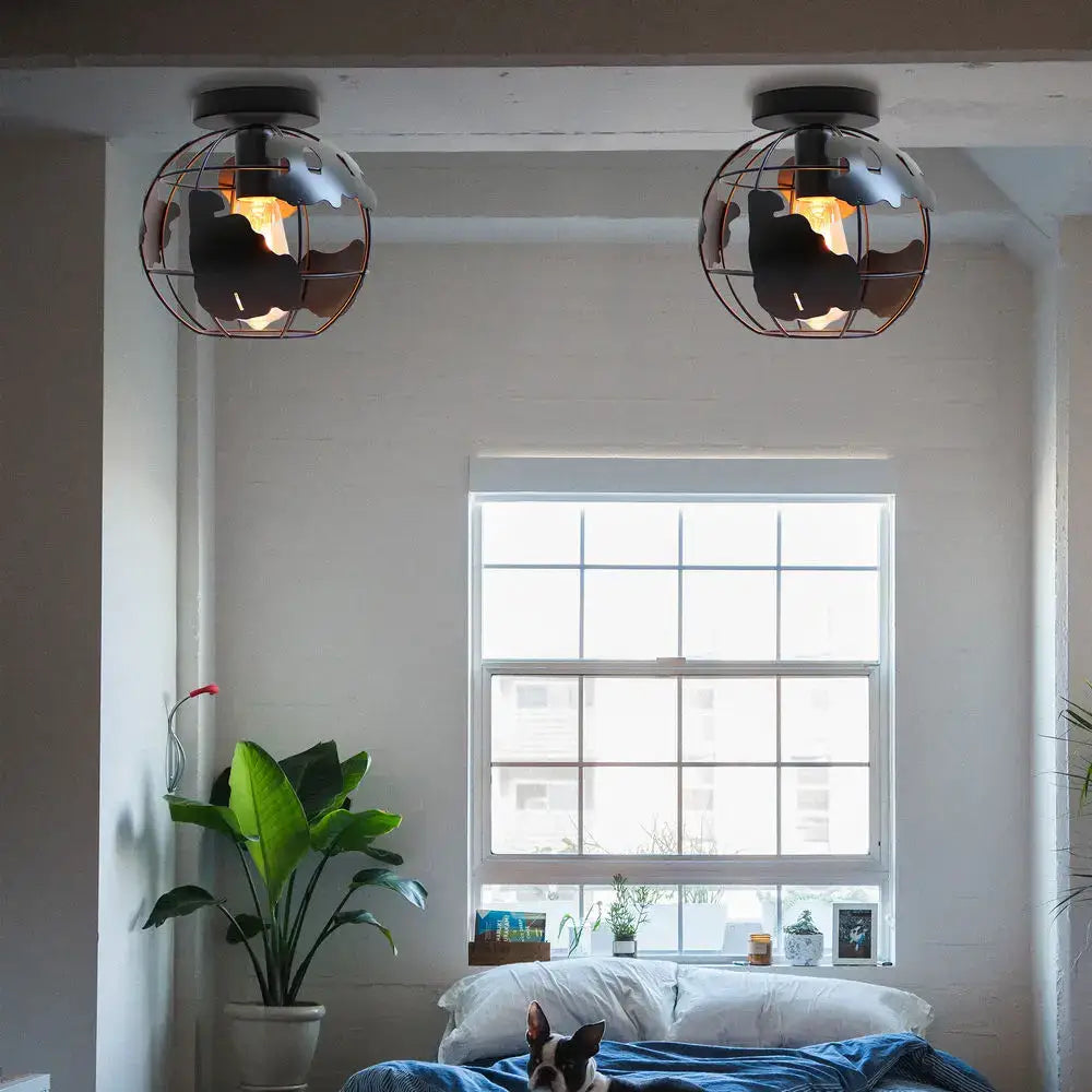Industrial-style globe ceiling light shade with black metal cage and warm filament bulbs for living room use