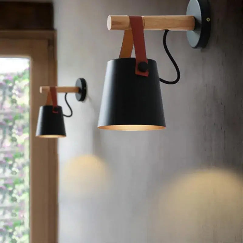 Modern black wooden wall light with a matte black conical lampshade suspended by red leather strap decorbites black wooden wall