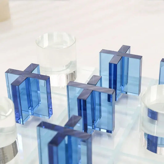 Modern blue acrylic decorbites crystal chessboard set featuring translucent cross-shaped blocks on a reflective surface
