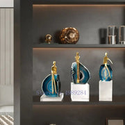 Three elegant blue agate crystal golden sculptures with gold-toned figurines on clear acrylic bases for decorbites agate crystal living room decor