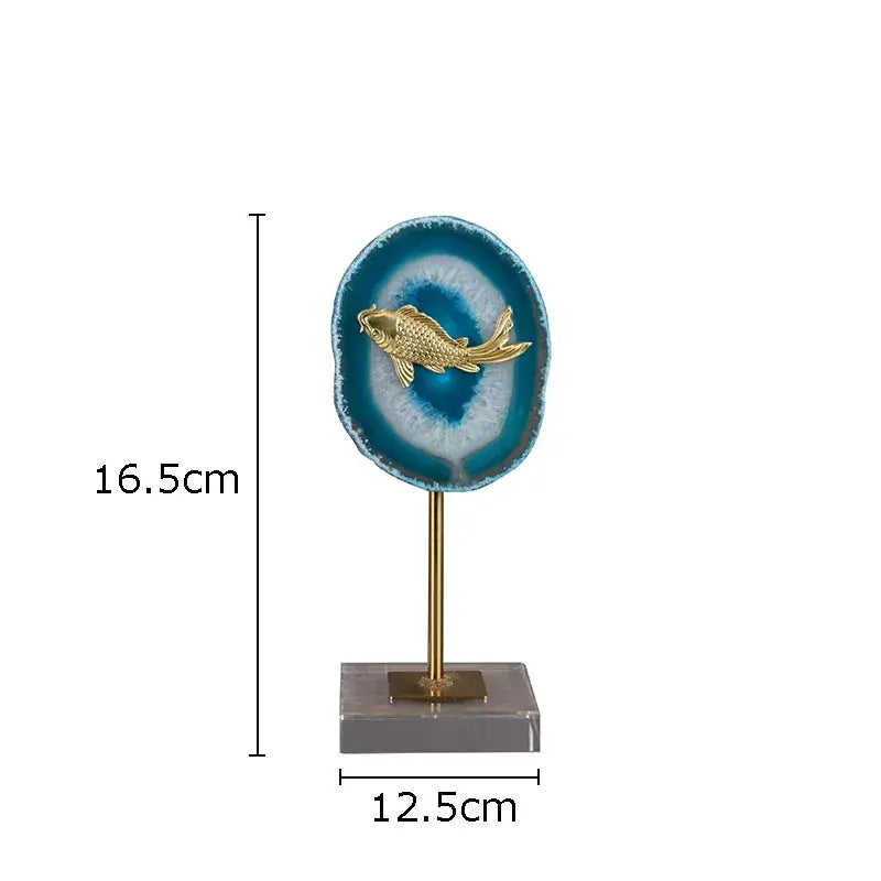 A golden fish figurine on a circular blue agate slice with brass stand by decorbites blue agate living room decor