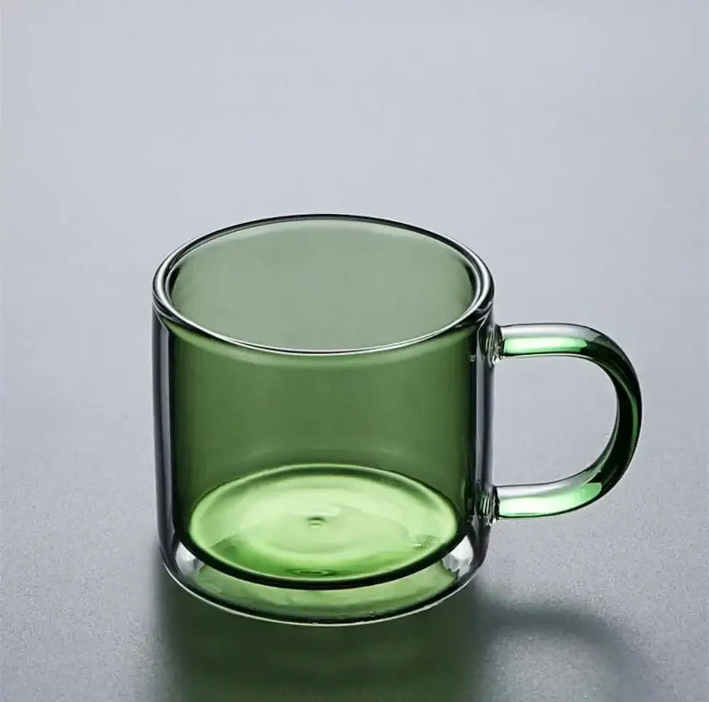 A translucent olive green glass mug with a minimalist design from a modern blue amber and green glass mugs set