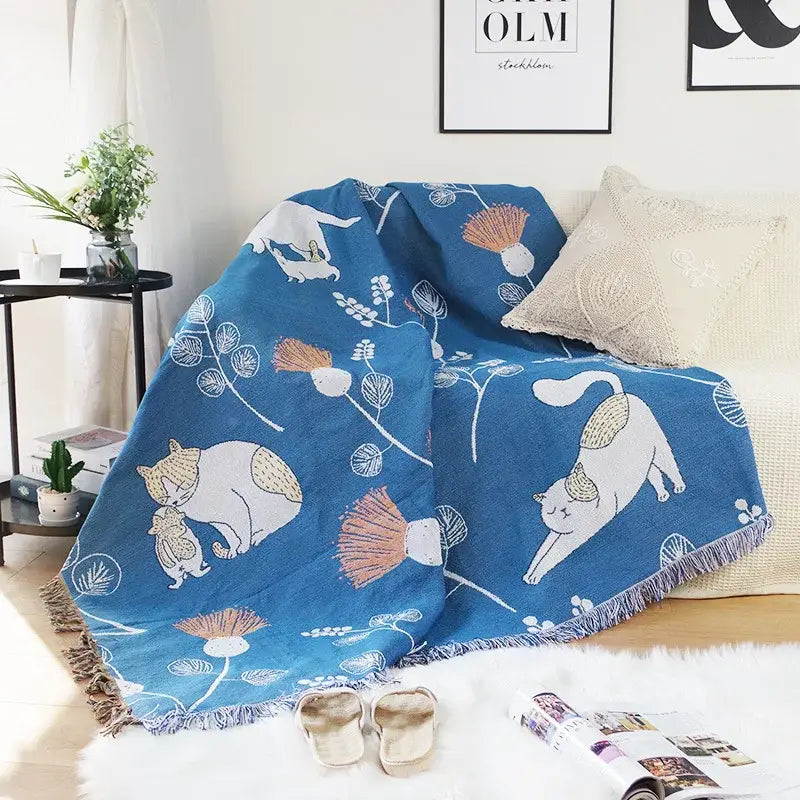 Modern blue cartoon cat woven throw blanket featuring white and beige cats with floral patterns and fringed edges decorbites cartoon cat