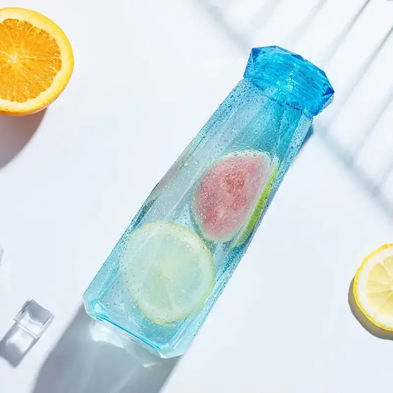 Modern blue diamond water bottle translucent faceted design filled with ice and citrus for kitchen and sport travel