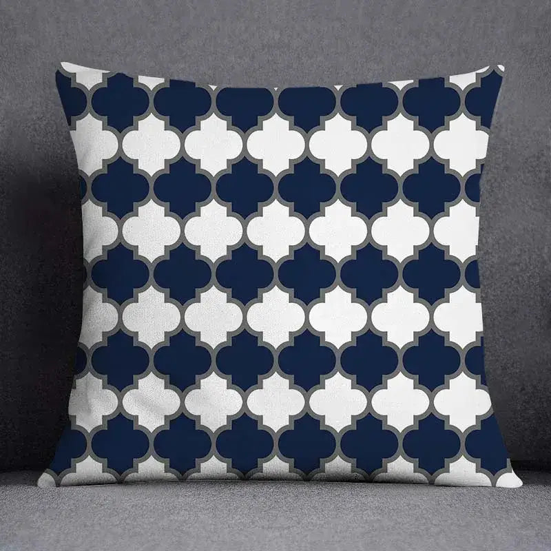 Square throw pillow with navy blue and white geometric floral design quatrefoil pattern outlined in gray for living room