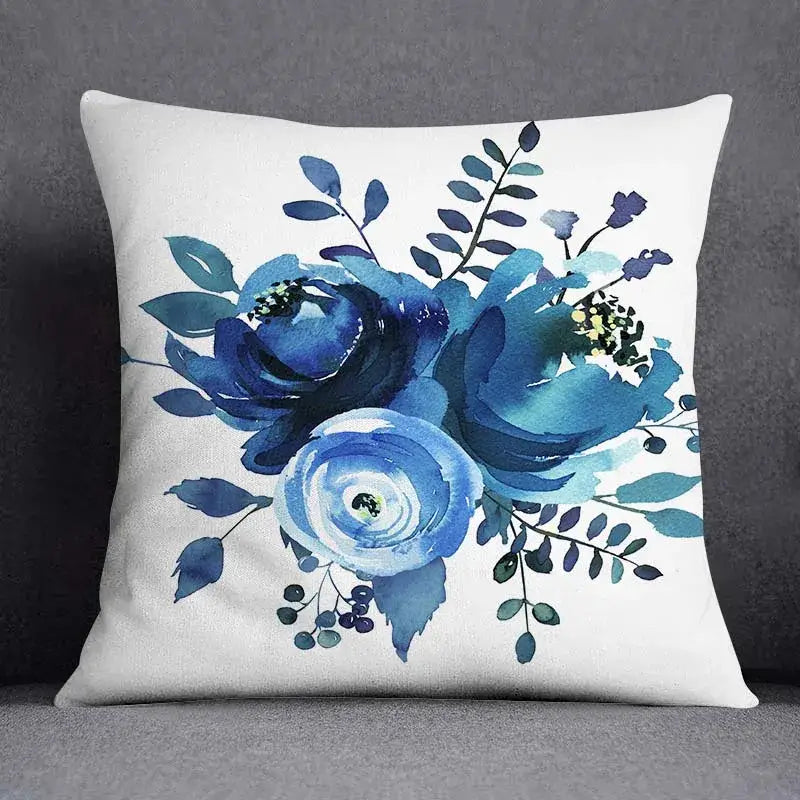 White throw pillow with blue roses and green leaves featuring a modern geometric floral design for living room use