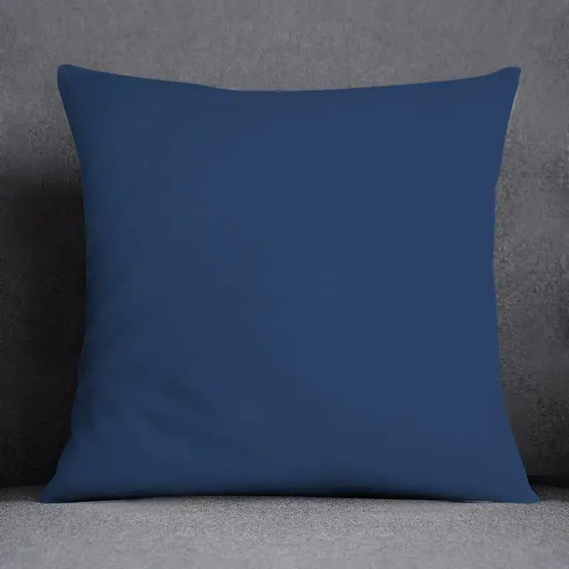 Solid navy blue square pillow with smooth fabric surface complementing a modern geometric floral design cushion