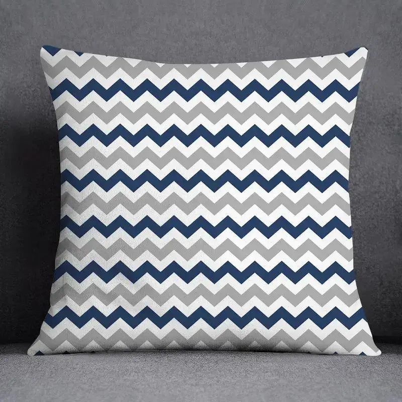 Square throw pillow with bold navy blue light gray and white chevron pattern featuring a geometric floral design