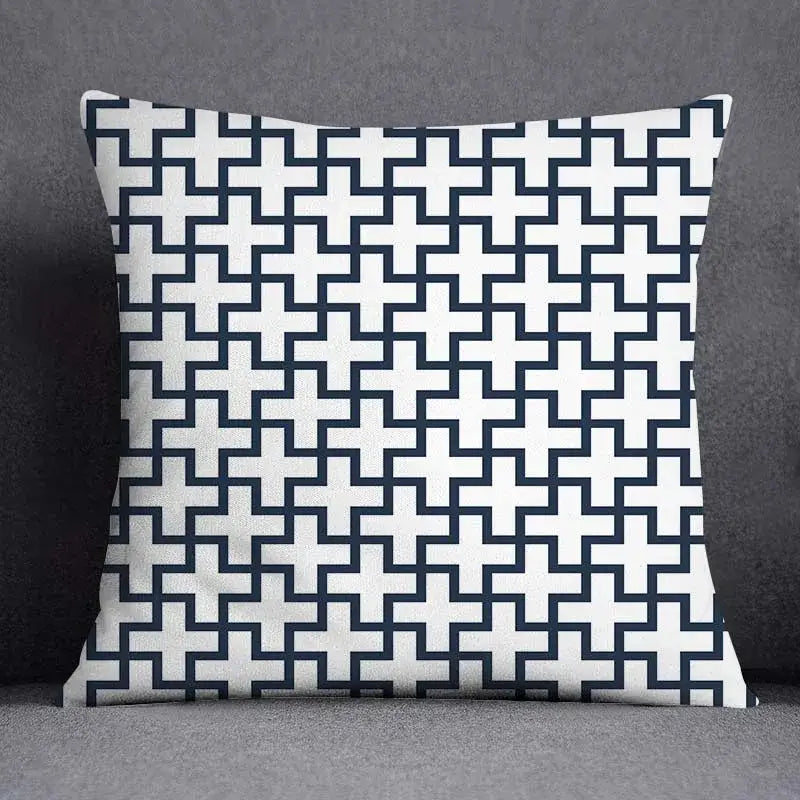 Square throw pillow with a modern blue geometric floral design of interlocking navy and white crosses on fabric surface
