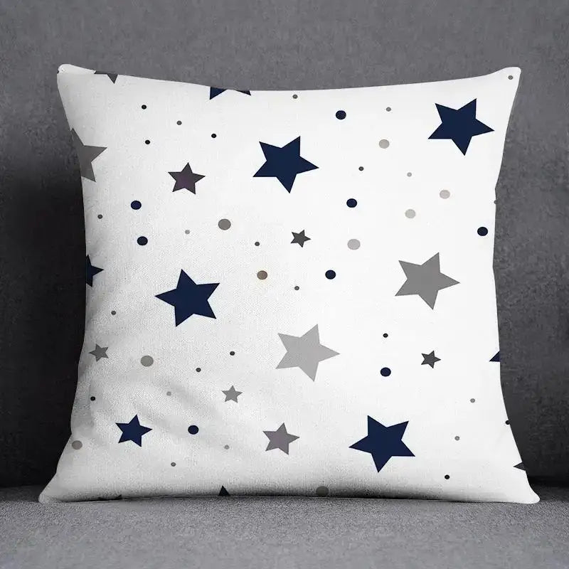 White throw pillow with modern blue geometric floral design featuring navy blue and gray stars and dots for living room use