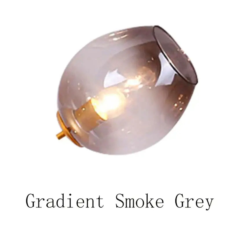 Modern blue glass black gold pendant light with gradient smoke grey glass and brass base featuring a warm bulb