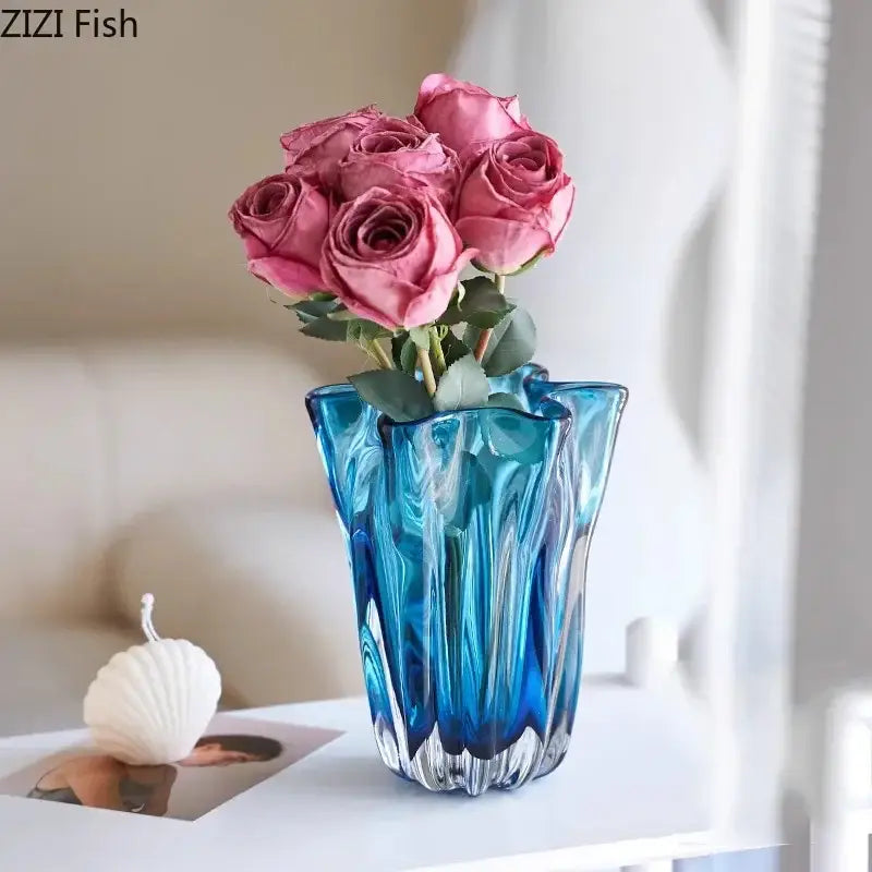 A vibrant blue glass hydroponic vase with a fluted design holds pink roses for modern office decorbites decor
