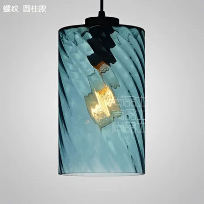 Modern blue glass led pendant lamp featuring a twisted design with visible filament bulb for dining room lighting