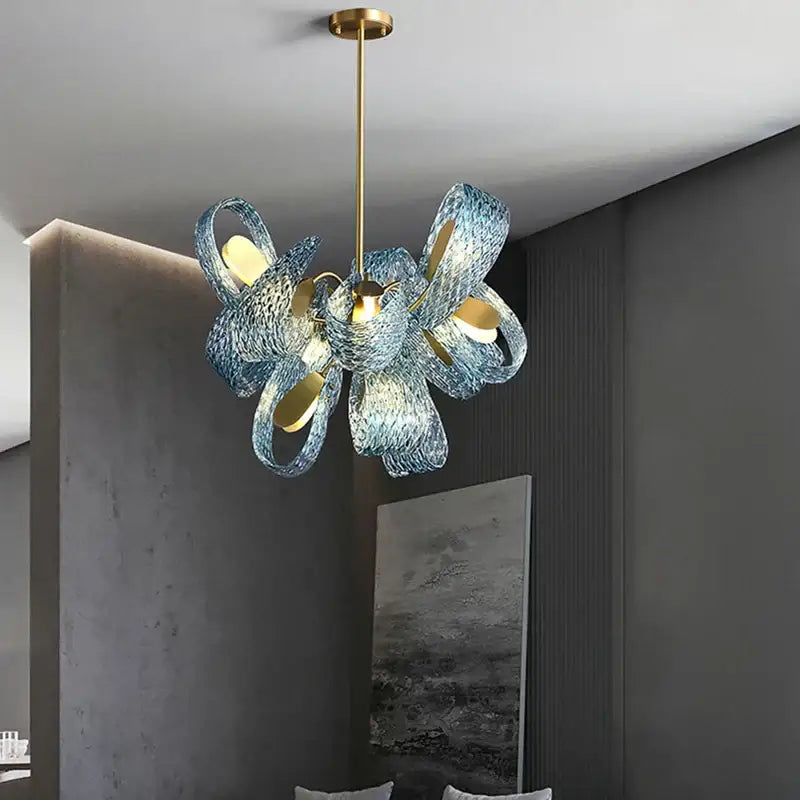 A modern blue glass led pendant lamp with intricate swirling shades and gold-toned metal accents for bedroom decorbites