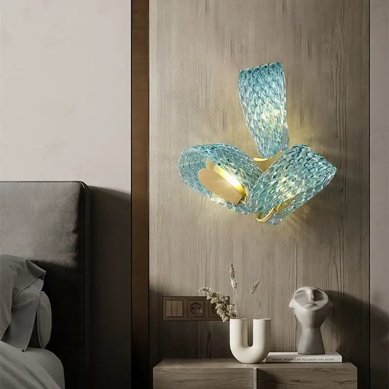 A modern wall-mounted pendant lamp with three blue glass led shades and gold-toned metal accents for dining room decorbites